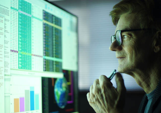 Man looking at data on a computer monitor