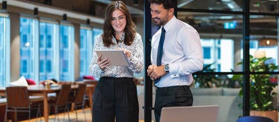 Two people working together on a tablet