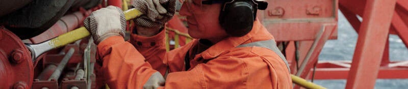 A worker with a hard hat working in a petroleum refinery