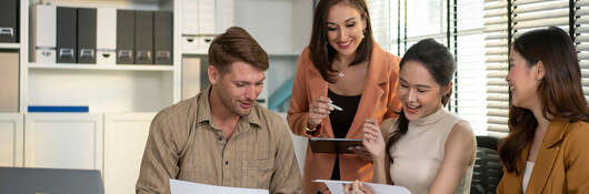 Four happy people working at a table together