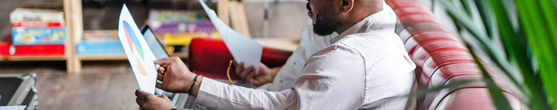 Two people sitting on a couch reading reports